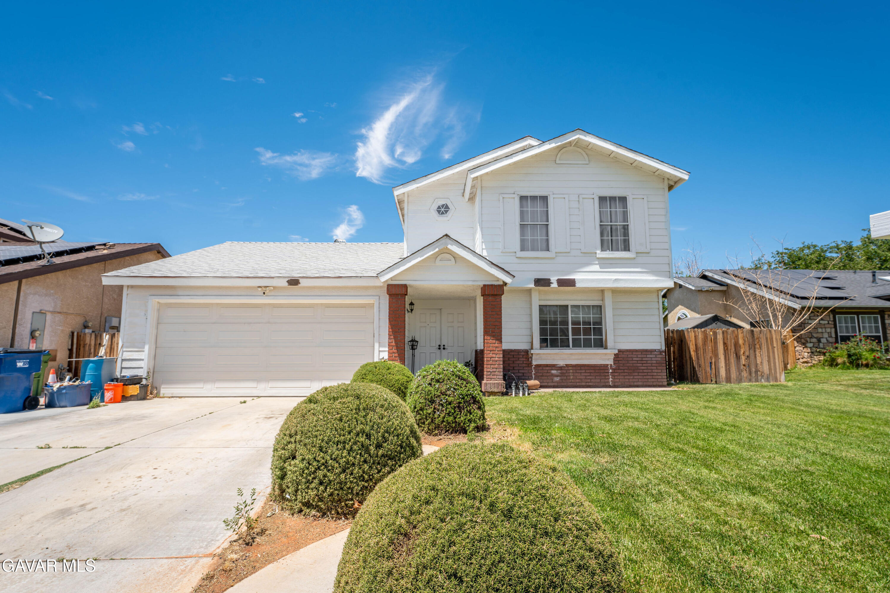 5009 East Ave R 11 Palmdale, CA 93552 - Photo 2 of 23 a view of a white house with a big yard and large trees