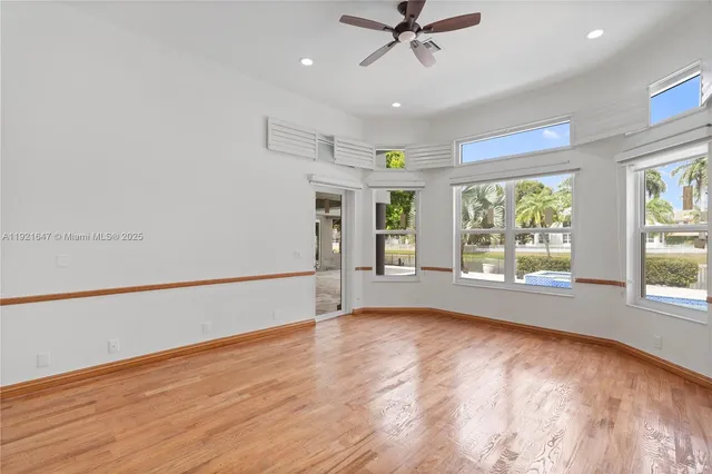 a large white kitchen with a sink and a large mirror