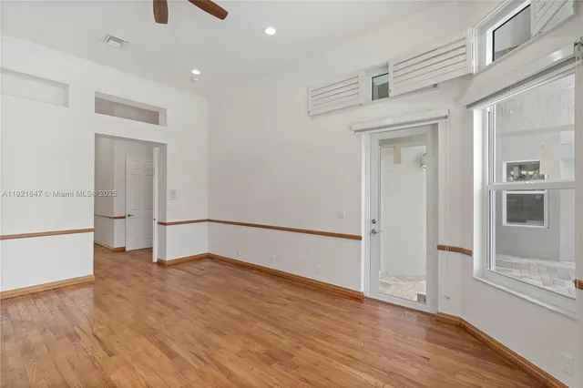 a large white kitchen with kitchen island granite countertop a large window