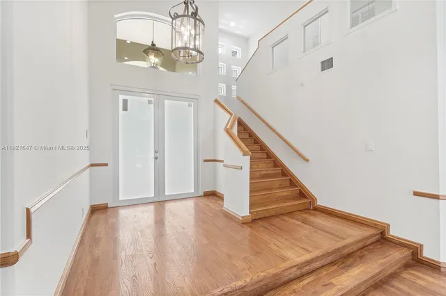 an empty room with wooden floor fireplace and windows