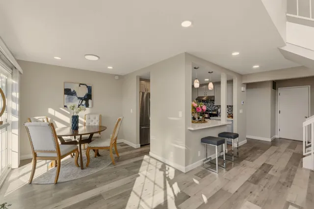 a dining room with furniture a fireplace and wooden floor