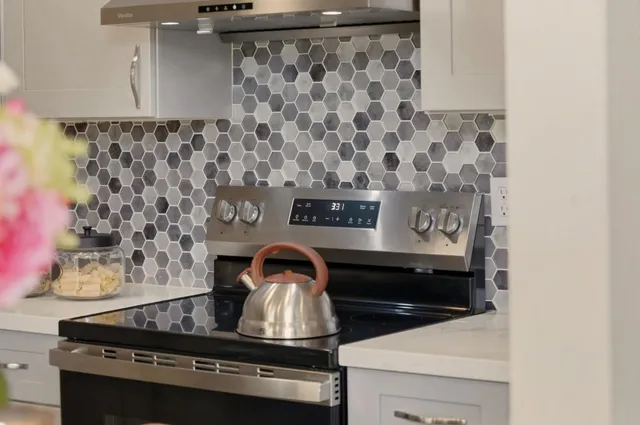 a kitchen with stainless steel appliances kitchen island granite countertop a refrigerator and a stove