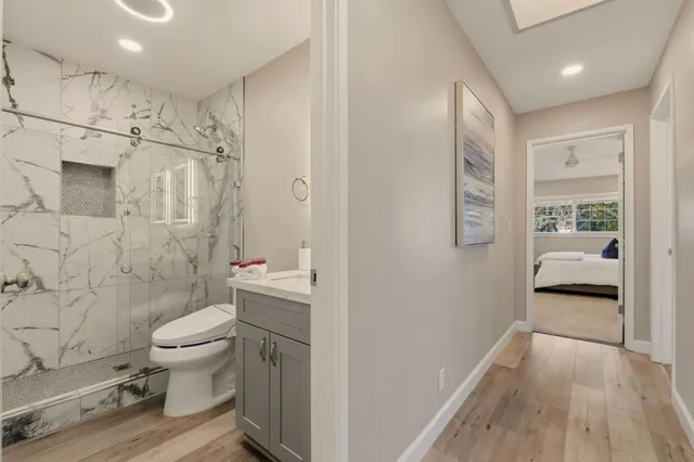 a bathroom with a granite countertop sink toilet and a mirror