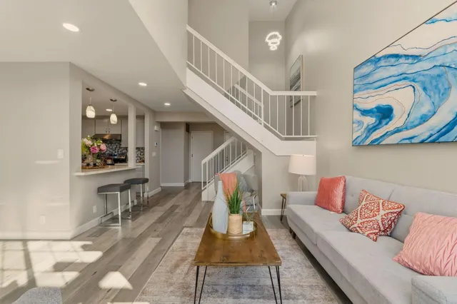 a living room with furniture and a dining table with kitchen view