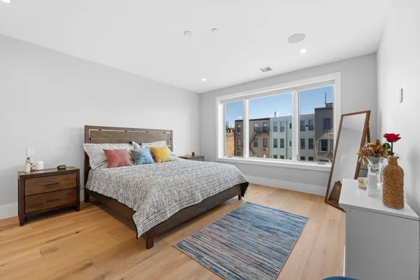 a bedroom with a bed and wooden floor
