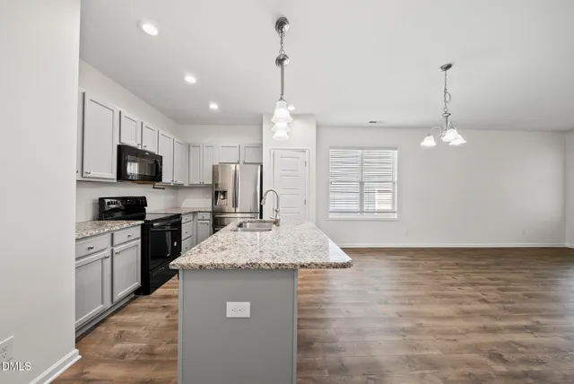 a view of kitchen with cabinets appliances and wooden floor