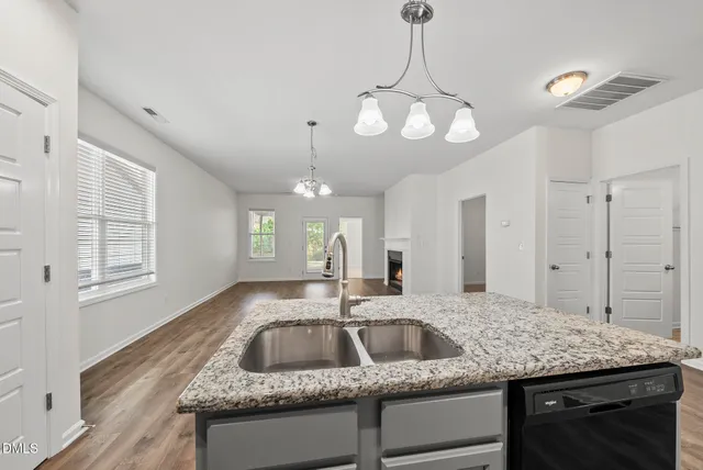 a kitchen with kitchen island granite countertop a sink a counter top space appliances and cabinets
