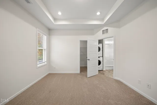 an empty room with washing machine and windows