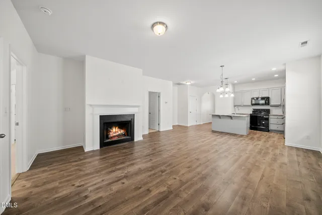 a view of an empty room with a fireplace and a window