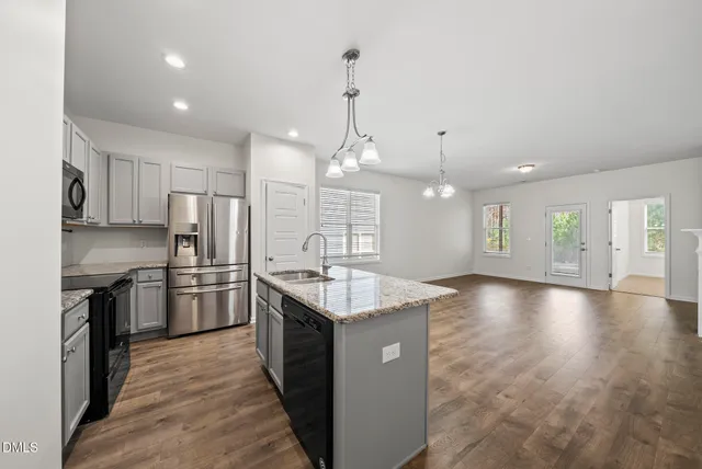 a kitchen with stainless steel appliances granite countertop a sink stove and refrigerator