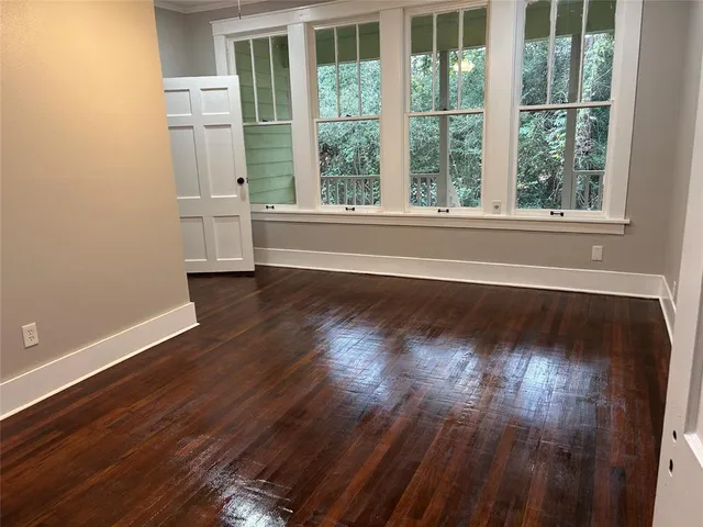 a view of a room with wooden floor and windows