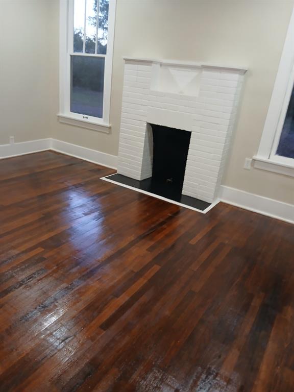 321 Kings Highway Mansfield, LA 71052 - Photo 9 of 22 an empty room with wooden floor fireplace and windows