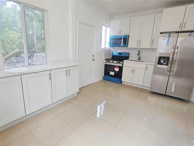 a kitchen with stainless steel appliances a refrigerator sink and cabinets