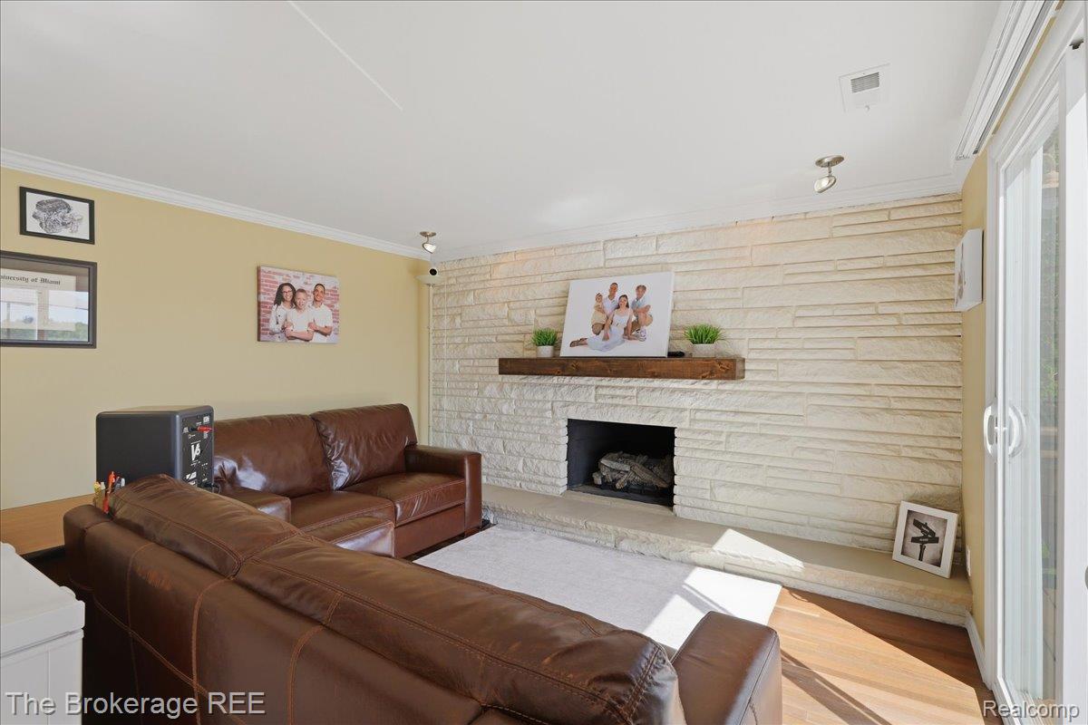 261 Reymont Road Waterford, MI 48327 - Photo 16 of 49 Living area featuring a stone accent wall with a fireplace, a wood mantel, and sliding glass doors
