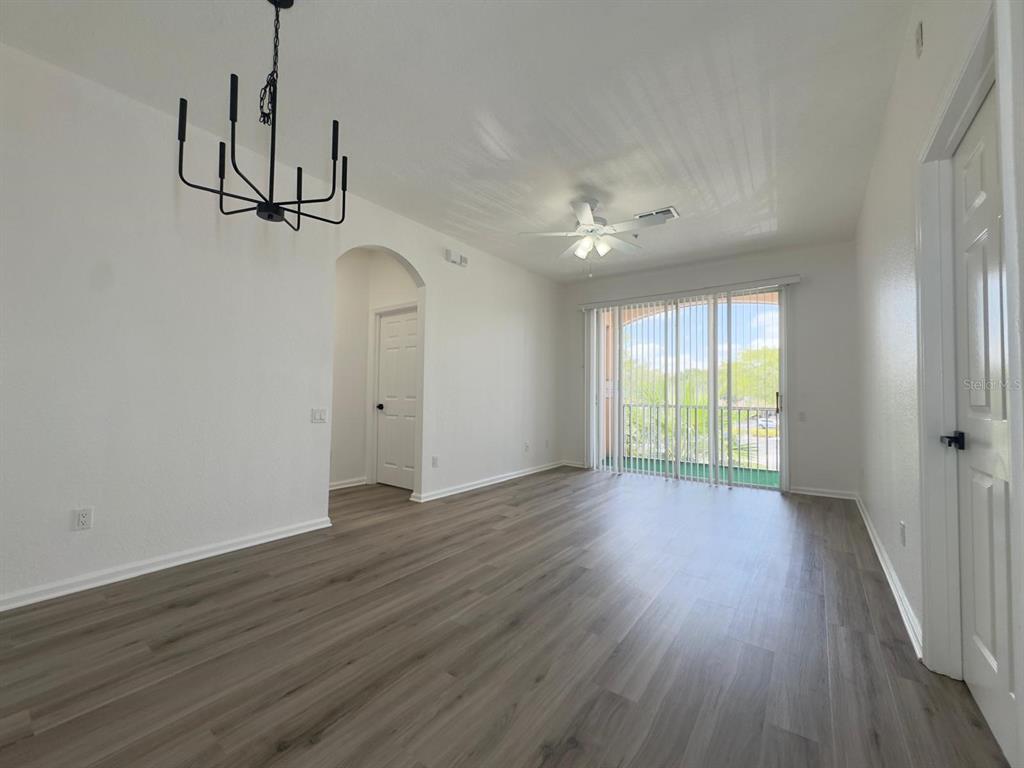 13512 Turtle Marsh Loop, Unit 729 Orlando, FL 32837 - Photo 23 of 42 a view of an empty room with wooden floor and a window