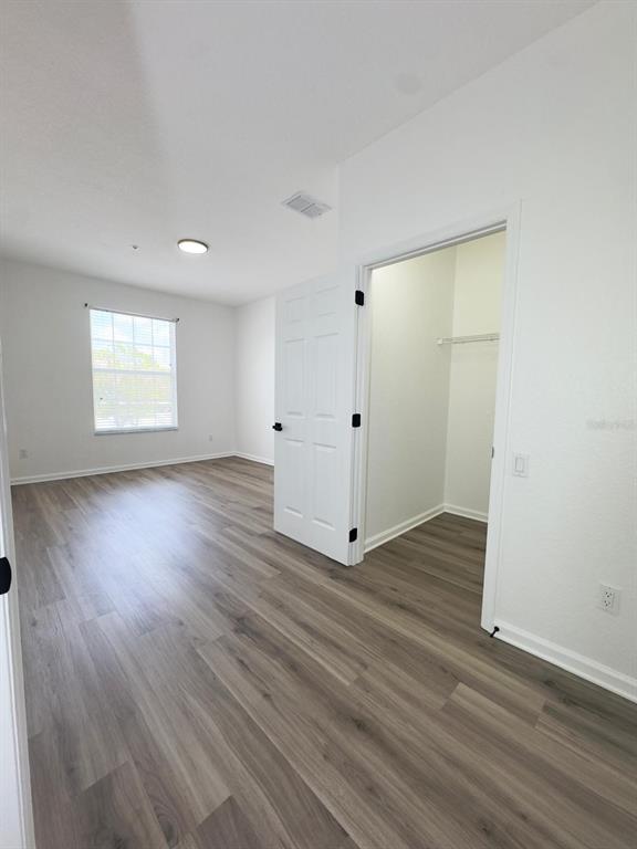 13512 Turtle Marsh Loop, Unit 729 Orlando, FL 32837 - Photo 28 of 42 an empty room with wooden floor and windows