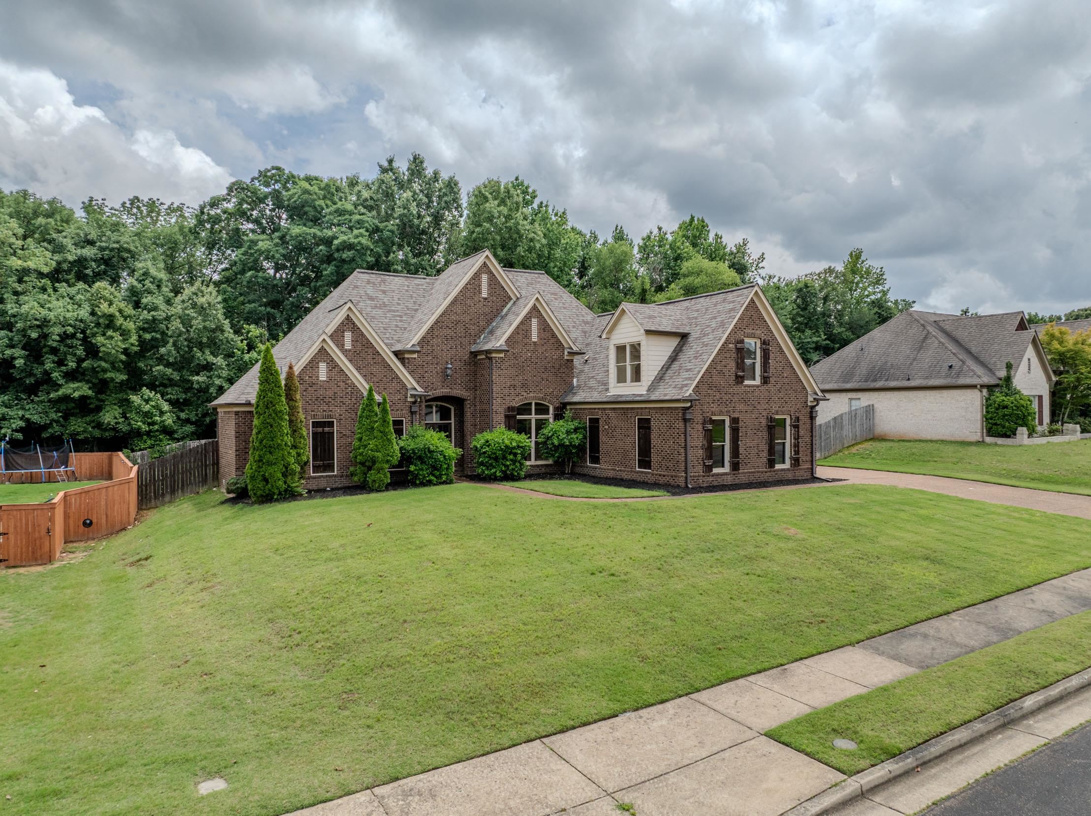 5380 Scarlet Ridge Drive Arlington, TN 38002 - Photo 32 of 35 Brick exterior with dormer windows, featuring a prominent front gable, dark shutters, and a sloped, shingled roof