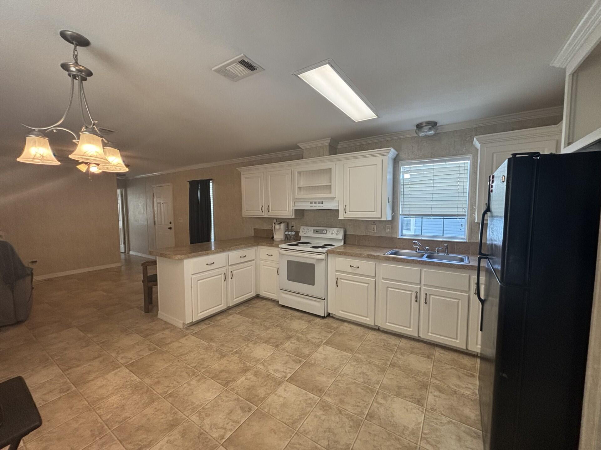 2990 Southwest 53rd Avenue Davie, FL 33314 - Photo 11 of 30 a large kitchen with granite countertop a refrigerator a sink dishwasher a stove and white cabinets