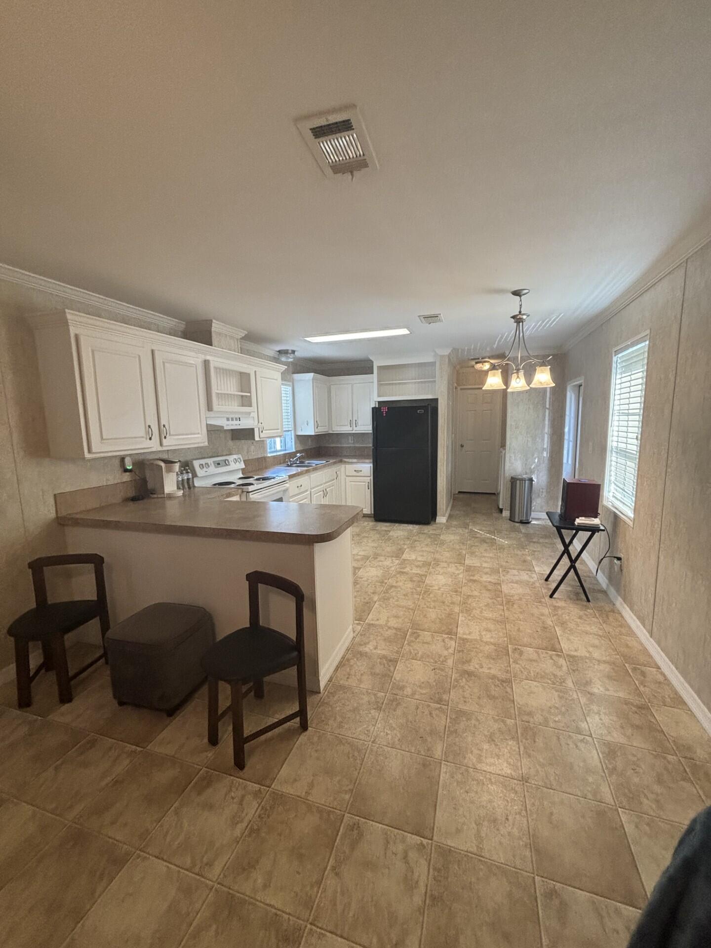 2990 Southwest 53rd Avenue Davie, FL 33314 - Photo 8 of 30 a kitchen with stainless steel appliances kitchen island granite countertop a table chairs sink and cabinets