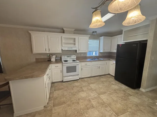 a kitchen with white cabinets and white appliances