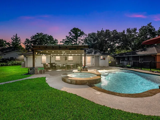 a view of a swimming pool with a table and chairs under an umbrella