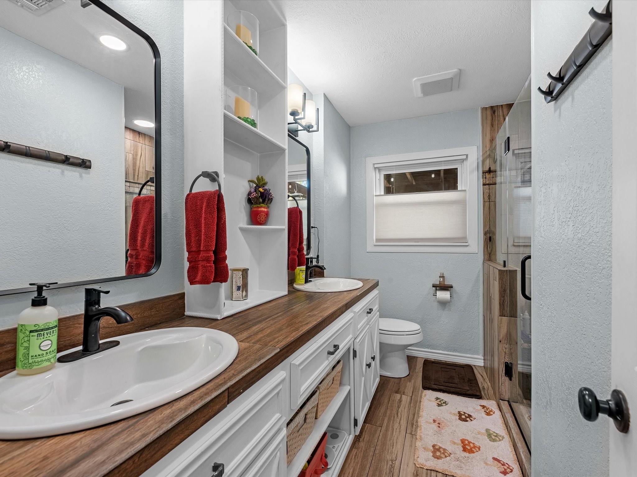 712 Barbara Street Tomball, TX 77375 - Photo 17 of 25 a bathroom with a granite countertop double vanity sink a mirror and a shower