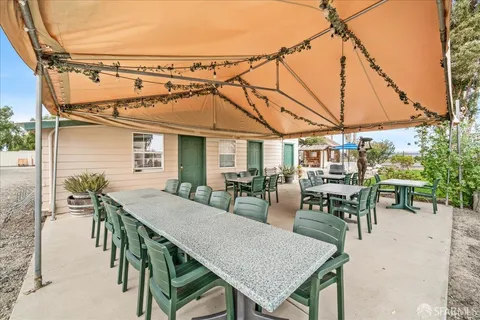a view of a patio with table and chairs with wooden fence