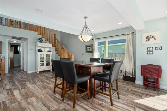 a view of a dining room with furniture a rug and wooden floor