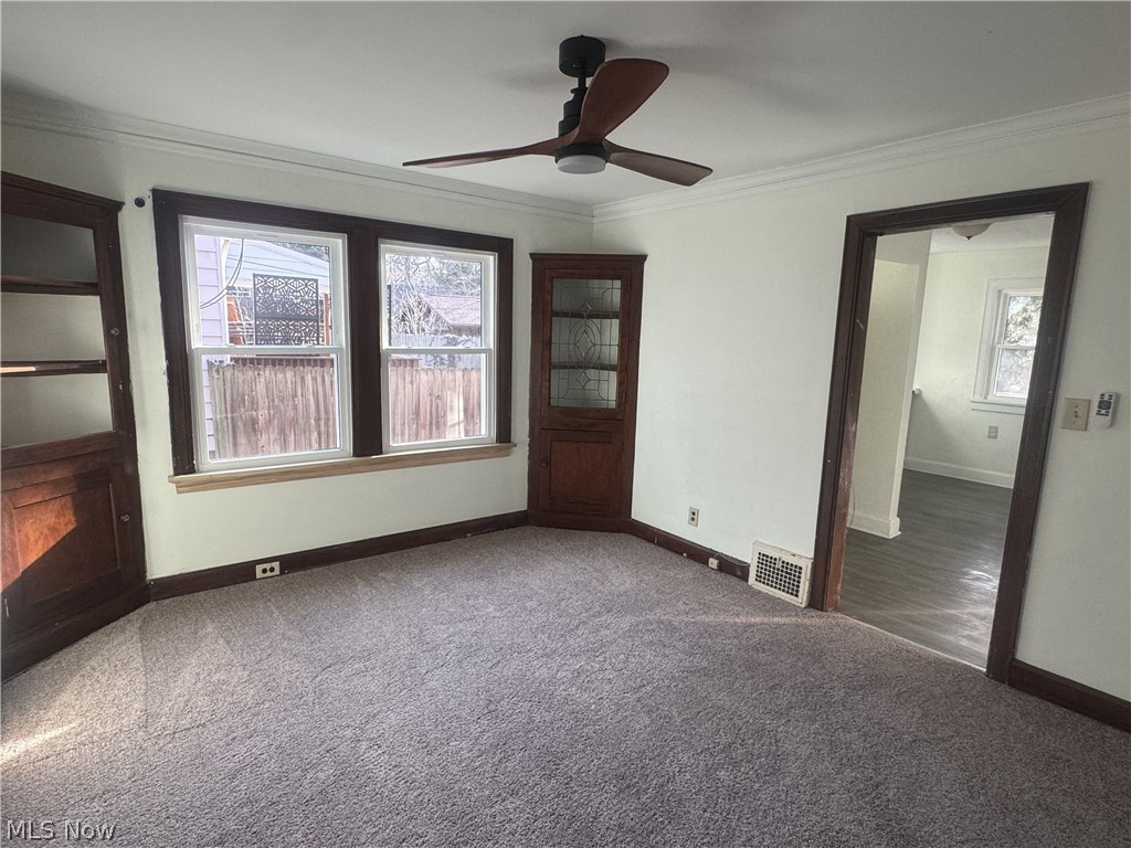 4058 Ardmore Road Cleveland, OH 44121 - Photo 6 of 14 Unfurnished room featuring ornamental molding, carpet floors, and a ceiling fan