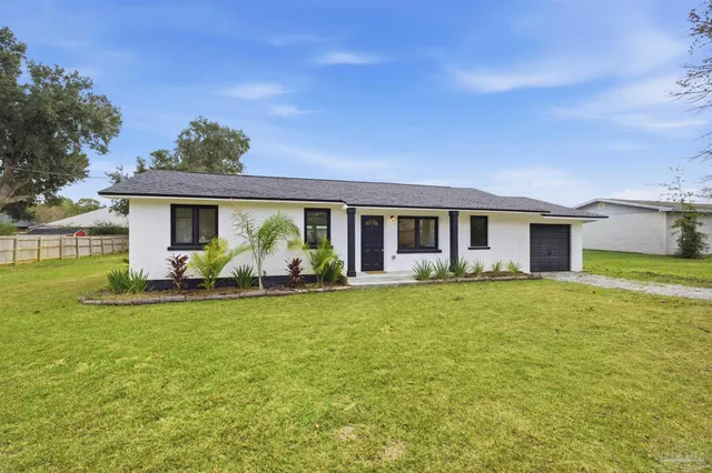 a front view of house with yard barbeque and outdoor seating
