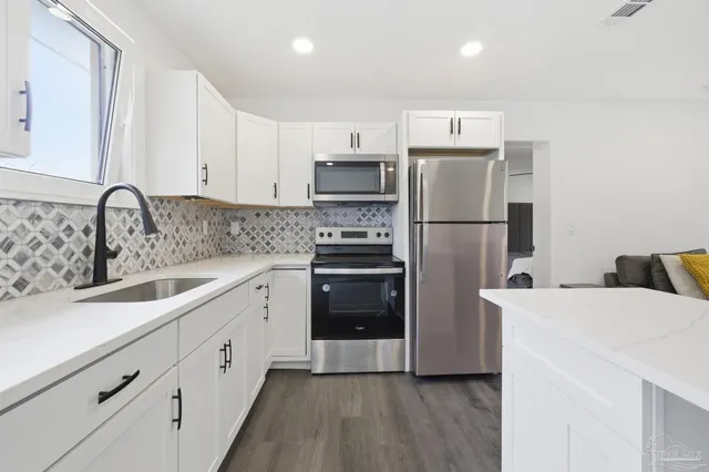 a kitchen with a refrigerator sink and cabinets