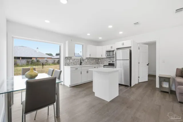 a kitchen with white cabinets and stainless steel appliances