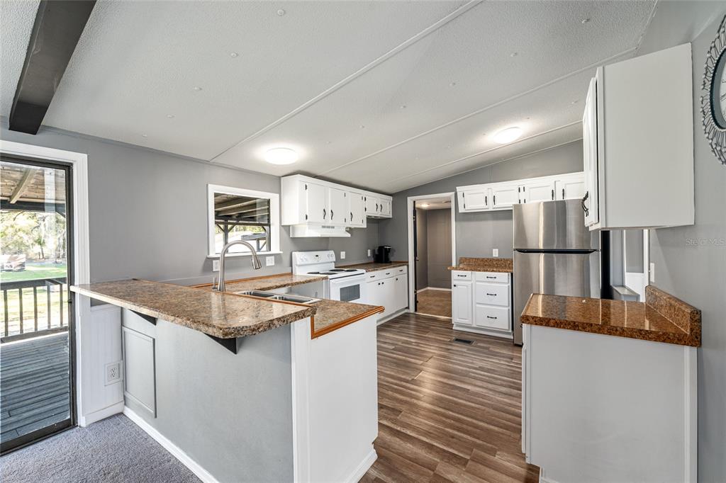 5600 Southeast 39th Street Trenton, FL 32693 - Photo 11 of 73 a kitchen with stainless steel appliances granite countertop a sink refrigerator and cabinets