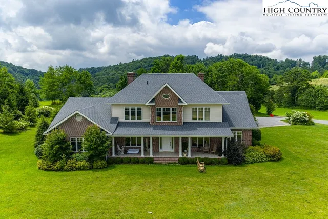 a aerial view of a house with swimming pool and green space