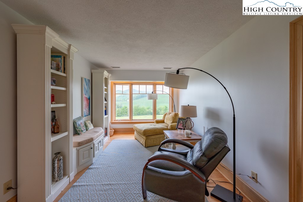 6985 Junaluska Road Boone, NC 28607 - Photo 24 of 49 a living room with furniture and a floor to ceiling window