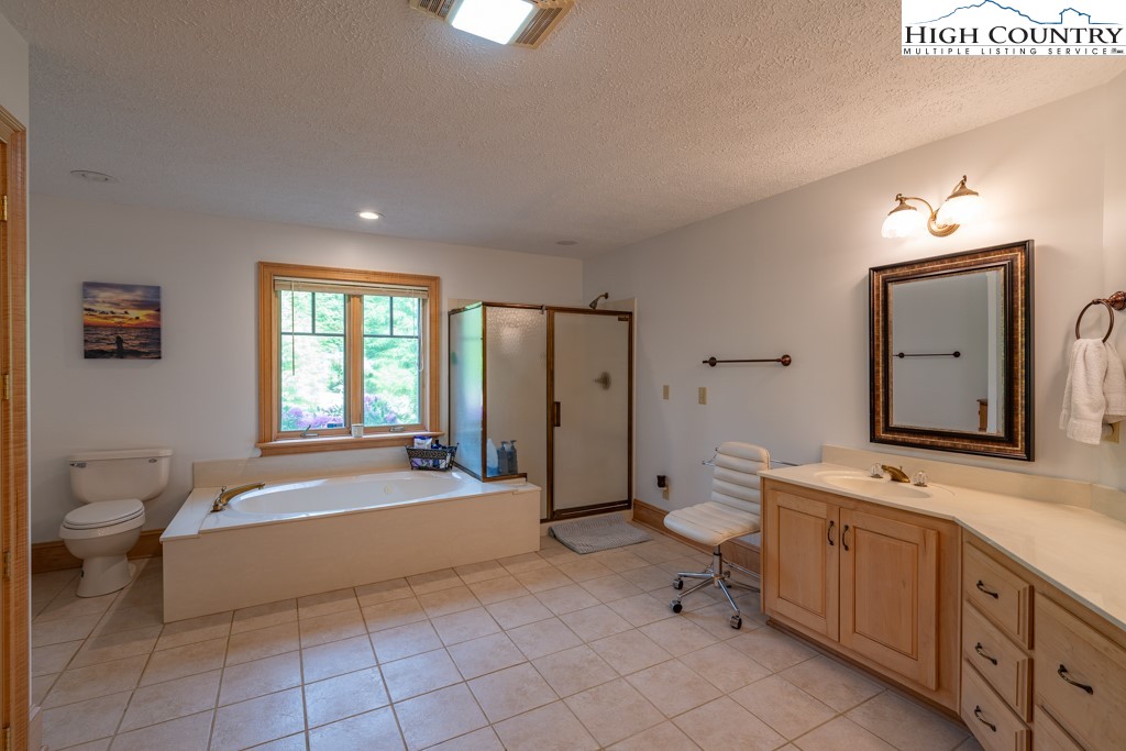 6985 Junaluska Road Boone, NC 28607 - Photo 42 of 49 a large spacious bathroom with a double vanity sink a mirror and a bathtub