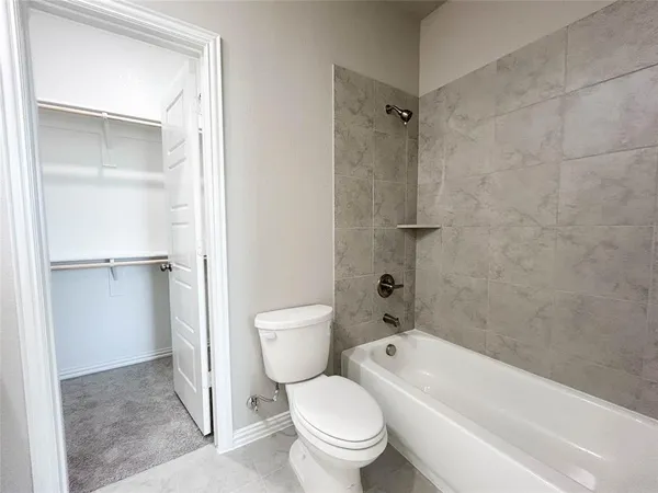 a white toilet sitting next to a bath tub