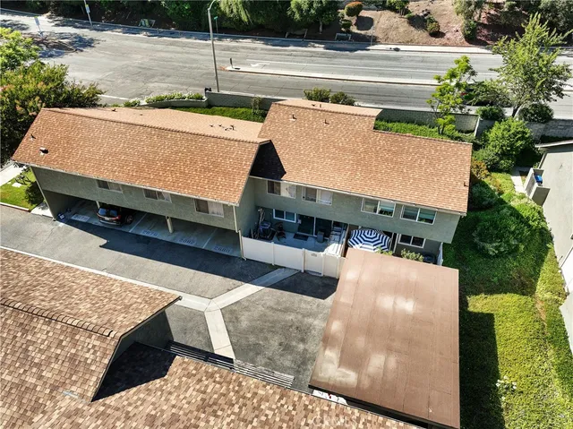 an aerial view of a house with a yard and street