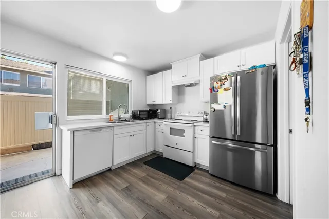 a kitchen with a refrigerator wooden floor and window