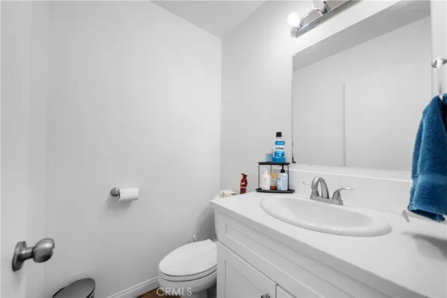 a bathroom with a granite countertop toilet sink and mirror