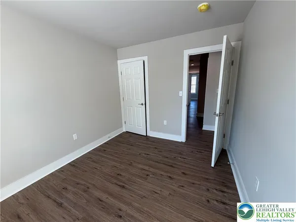 a view of a hallway with wooden floor and closet