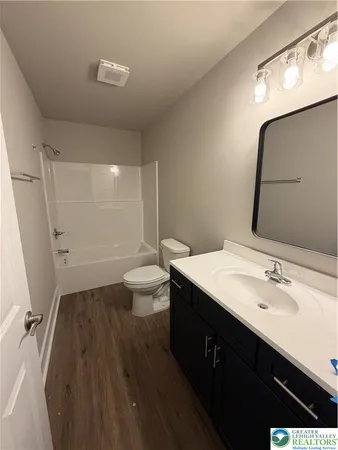 a bathroom with a sink a toilet a mirror and shower