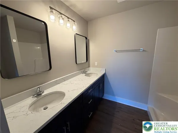 a bathroom with a double vanity sink and a mirror