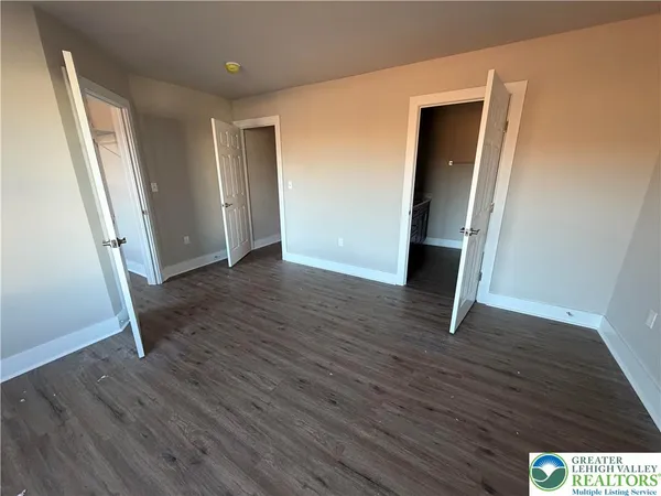 an empty room with wooden floor and entrance