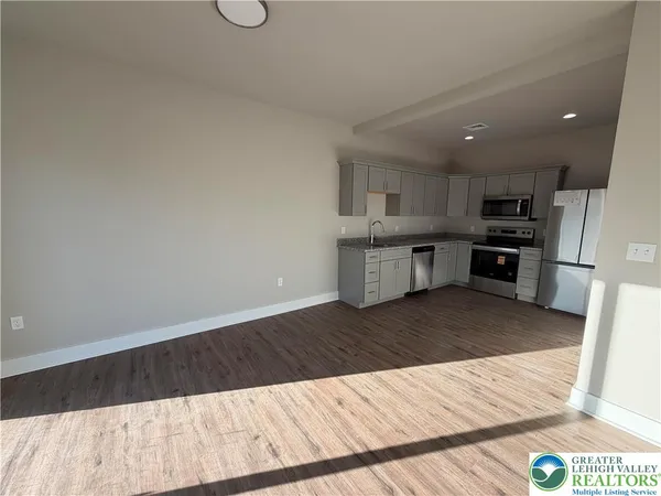 a kitchen with granite countertop a stove top oven and cabinets