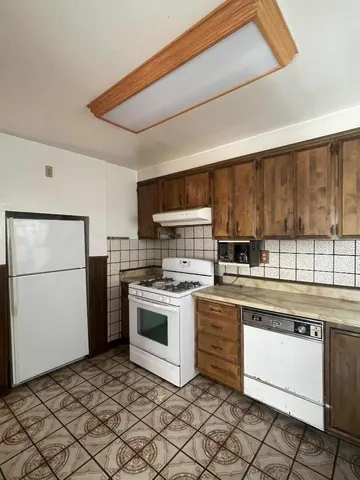 a kitchen with a stove top oven sink and cabinets