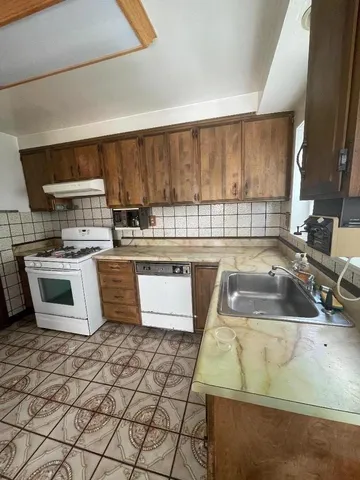 a kitchen with a stove sink and cabinets