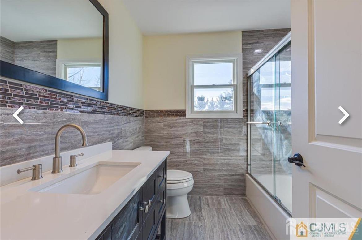 19 Henry Street Edison, NJ 08820 - Photo 21 of 33 a bathroom with a sink and mirror with toilet