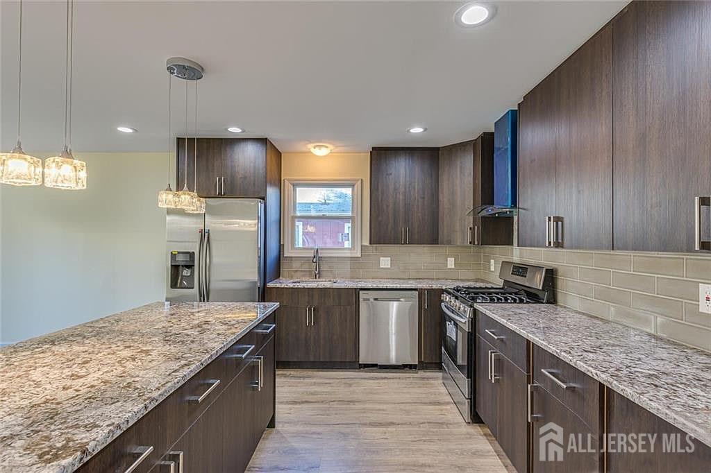 19 Henry Street Edison, NJ 08820 - Photo 7 of 33 a kitchen with stainless steel appliances granite countertop a sink stove and refrigerator