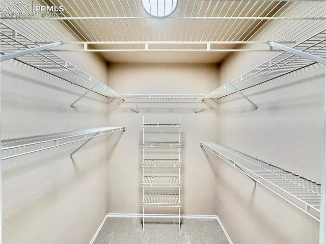 a view of walk in closet with empty racks